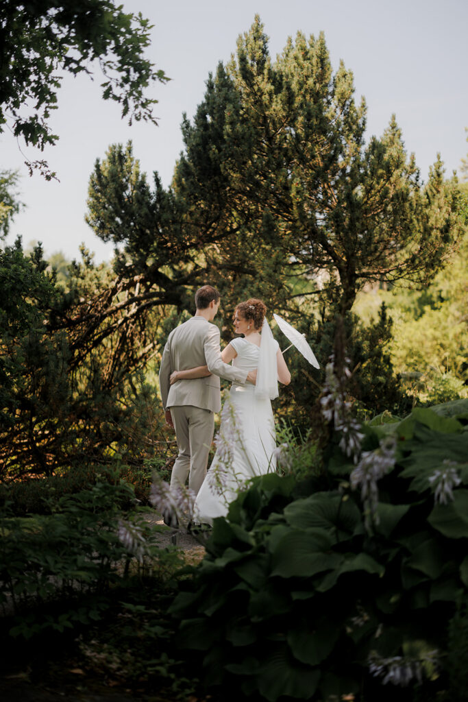 Hochzeitstag Ablaufregie: Perfektes Timing für deine Traumhochzeit Ein Hochzeitstag dauert oft zwölf Stunden oder länger – doch viele Paare unterschätzen, wie viel Zeit einzelne Programmpunkte wirklich benötigen. Ohne durchdachte Ablaufregie entstehen Verzögerungen, gestresste Dienstleister und unnötige Mehrkosten. Dieser Beitrag zeigt euch, wie ihr euren Hochzeitstag in 30-Minuten-Slots strukturiert, realistische Zeitpuffer einplant und die Koordination zwischen Fotograf, Caterer und Location-Team organisiert. Ihr erfahrt, welche versteckten Zeitfresser lauern, wie ihr auf Verspätungen reagiert und warum professionelles Timing den Unterschied zwischen Chaos und entspannter Feier ausmacht. Warum eine durchdachte Hochzeitsplanung mit Ablaufregie den Unterschied macht Der Unterschied zwischen grober Hochzeitsplanung und detaillierter Ablaufregie Viele Paare planen ihre Hochzeit mit einer groben Vorstellung: Trauung um 14 Uhr, dann Empfang, später Dinner. Diese oberflächliche Planung unterscheidet sich fundamental von einer professionellen Ablaufregie. Während die grobe Planung nur Meilensteine festlegt, arbeitet die detaillierte Ablaufregie mit konkreten Zeitfenstern von 30 Minuten, definiert wer wofür zuständig ist und berücksichtigt, wer wann auf wen warten muss. Eine durchdachte Ablaufregie folgt der SMART-Methode: Jeder Programmpunkt ist konkret formuliert, messbar in seiner Dauer, machbar mit den vorhandenen Ressourcen, relevant für den Gesamtablauf und klar terminiert. Statt vager Formulierungen wie "danach Fotos" entsteht ein präziser Plan: "15:00 bis 15:45 Uhr Gruppenfotos mit 8 definierten Motivkombinationen, Verantwortlich: Fotograf Thomas, Trauzeuge sammelt Gäste". Die Eisenhower-Matrix hilft bei der Priorisierung: Vertragsabschlüsse mit Location und professionellen Hochzeitsfotografen sind dringend und wichtig, während Detailfragen zur Menükartenschrift delegiert werden können. Was passiert, wenn das Timing am Hochzeitstag nicht stimmt Fehlende Zeitpuffer führen zu Dominoeffekten: Die Braut kommt 30 Minuten später als geplant, die Trauung verschiebt sich, die Golden Hour für traumhafte Paarfotos verstreicht ungenutzt, und das Dinner beginnt mit hungriger Stimmung bei den Gästen. Terminkollisionen entstehen, wenn die Hochzeitsdekoration noch nicht fertig ist, während die ersten Gäste eintreffen. Teuer wird es bei stundenbasierten Dienstleistern: Ein Fotograf mit 150 Euro pro Stunde, der durch Verspätungen zwei Stunden länger bleiben muss, bedeutet 300 Euro Mehrkosten. Das Cateringpersonal rechnet nach Stunden, jede ungeplante Verlängerung treibt die Kosten hoch. Unterschätzte Zeitfresser verschärfen das Problem: 80 Gäste für Gruppenfotos zu organisieren dauert nicht 20, sondern realistisch 45 Minuten. Die Empfangslinie bei 120 Gästen benötigt mindestens 40 Minuten. Wer ist für die Ablaufregie verantwortlich und warum das wichtig ist Die Verantwortung für die Ablaufregie muss klar definiert sein. Ohne zentrale Koordination entstehen Lücken und Überschneidungen. Das SBAR-Kommunikationsmodell strukturiert den Informationsfluss: Situation beschreibt den aktuellen Stand, Background umfasst alle Vertragsdetails der Dienstleister, Assessment bewertet Risiken wie Wetterumschwünge, und Recommendation definiert konkrete nächste Schritte. Ein professioneller Hochzeitsplaner übernimmt diese zentrale Rolle und verhindert, dass Fotograf, Band und Caterer gleichzeitig dieselbe Aufmerksamkeit fordern. Er erstellt einen Time-Blocking-Plan mit festen, visualisierten Zeitblöcken in digitalen Tools, die alle Beteiligten einsehen können. Der perfekte Zeitplan für euren Hochzeitstag: Vormittag bis Trauung Getting Ready bis Ankunft Location: Realistische Zeitfenster in 30-Minuten-Slots Der Hochzeitstag beginnt oft zwischen 9:00 und 10:00 Uhr mit dem Getting Ready. Für professionelles Make-up und Haarstyling solltet ihr pro Person 90 Minuten einplanen, bei der Braut gerne 120 Minuten. Parallel arbeitet die Brautmode Spezialistin am finalen Styling. 9:00 bis 10:30 Uhr: Hair and Make-up Braut 10:30 bis 11:00 Uhr: Ankleiden und letzte Details 11:00 bis 11:30 Uhr: Getting Ready Fotos 11:30 bis 12:00 Uhr: Transfer zur Trauungslocation Trauzeremonie und Gratulationen: Zeitplanung nach Location-Typ Die Zeitplanung variiert erheblich je nach Hochzeitslocation. Ein historisches Schloss mit weitläufigen Parkanlagen und langen Gehwegen zwischen Trauungssaal und Empfangsbereich braucht andere Zeitpuffer als eine moderne Event-Location, in der alles unter einem Dach liegt. Für die Zeremonie selbst rechnet mit 30 bis 45 Minuten, abhängig vom Format. Die anschließende Gratulationslinie bei 100 Gästen benötigt realistische 35 bis 40 Minuten, nicht die oft eingeplanten 15 Minuten. Versteckte Zeitfresser: Empfangslinie, Anreise zwischen Locations und Verkehrspuffer Versteckte Zeitfresser gefährden selbst gut geplante Abläufe. Die Anreise zwischen Standesamt und Kirche sollte mit realistischen Verkehrspuffern kalkuliert werden: Nicht 10, sondern 25 bis 30 Minuten einplanen. Timing perfekt planen: Empfang bis Dinner Sektempfang, Gruppenfotos und Paarshoot: Wie viel Zeit braucht ihr wirklich Der Sektempfang beginnt idealerweise direkt nach der Zeremonie und dient als Puffer, während ihr als Brautpaar eure ersten Paarfotos macht. Plant für den Sektempfang 60 bis 90 Minuten ein, diese Zeit brauchen eure Gäste, um anzukommen und sich auszutauschen. Parallel dazu solltet ihr 45 bis 60 Minuten für euer Paarshooting reservieren. Der Fotograf benötigt diese Zeit für verschiedene Locations auf dem Gelände und unterschiedliche Lichtsituationen. Golden Hour und besondere Momente gezielt im Zeitplan verankern Die Golden Hour, die magische Stunde vor Sonnenuntergang, ist fotografisch unersetzlich. Sie muss gezielt im Zeitplan verankert werden. Plant bewusst 30 Minuten in diesem Zeitfenster für ein zweites Paarshooting ein, auch wenn das bedeutet, kurz das Dinner zu unterbrechen. Dinner-Timing: Von der Begrüßung bis zum ersten Gang Das Dinner sollte spätestens 2,5 bis 3 Stunden nach Beginn des Sektempfangs starten, damit eure Gäste nicht übermäßig hungrig werden. Der Ablauf gliedert sich in klare Phasen: Gäste nehmen Platz (15 Minuten), Begrüßung durch das Brautpaar (10 Minuten), erster Gang wird serviert (ab Minute 25). Abendprogramm bis Ausklang: Den perfekten Abschluss planen Hochzeitstorte, Reden und Tanz: Zeitfenster richtig timen Das Abendprogramm ist der emotionale Höhepunkt eures Hochzeitstags und braucht genauso viel Planung wie alles davor. Der Anschnitt der Hochzeitstorte passt idealerweise zwischen 20:00 und 20:30 Uhr. Dann sind alle satt vom Dinner und die Konzentration ist noch da. Plant für diesen Moment inklusive Fotos etwa 15 Minuten ein. Die Reden der Trauzeugen und Familie fügen sich am besten direkt vor oder nach dem Dessert ein, wobei ihr pro Rede ungefähr 5 bis 7 Minuten rechnen solltet. Bei vier Rednern bedeutet das ein Zeitfenster von 20:00 bis 20:30 Uhr. Die Eröffnung der Tanzfläche durch euren ersten Tanz als Ehepaar ist der Übergang zur ausgelassenen Feier. Legt diesen Moment auf etwa 21:00 Uhr, wenn die Dämmerung eine stimmungsvolle Atmosphäre schafft. Der DJ für eure Hochzeit sollte unmittelbar danach die Gäste zum Mittanzen animieren und die Musik schrittweise aufbauen. Plant für die gesamte Tanzphase bis Mitternacht mindestens drei Stunden ein, damit sich eine richtige Partystimmung entwickeln kann. Denkt dabei auch an besondere Momente wie einen Überraschungstanz oder das Werfen des Brautstraußes um 22:30 Uhr. Ein kurzes Feuerwerk oder Funkenregen kann um 23:30 Uhr einen zusätzlichen Akzent setzen. Pufferzeiten einplanen: Warum 15 Minuten Reserve goldwert sind Pufferzeiten sind das Geheimnis entspannter Hochzeitsplanung und sollten zwischen jedem größeren Programmpunkt eingeplant werden. Diese Zeitreserven sind euer Sicherheitsnetz für unvorhergesehene Verzögerungen. Sie verhindern, dass sich Verspätungen wie Dominosteine durch den gesamten Ablauf ziehen. Zwischen dem Ende des Dinners und dem Tortenschnitt solltet ihr beispielsweise bewusst 15 Minuten einplanen, in denen Gäste zur Toilette gehen oder sich unterhalten können. Auch zwischen der letzten Rede und der Eröffnung der Tanzfläche macht ein 10-minütiger Puffer Sinn, damit die Band oder der DJ sich vorbereiten kann und die Gäste ihre Positionen einnehmen können. Diese zusätzlichen Minuten sind wie ein Airbag für euren Zeitplan und geben euch die Möglichkeit, auf Spontanes zu reagieren, ohne in Stress zu geraten. Bei der Hochzeitsplanung gilt die Faustregel: Lieber 15 Minuten Puffer einplanen und diese Zeit geschenkt bekommen, als gehetzt von einem Programmpunkt zum nächsten zu eilen. Besonders wichtig sind Pufferzeiten vor zeitgebundenen Momenten wie der Golden Hour für Fotos oder dem vertraglich vereinbarten Ende der Location-Miete. Ein professioneller Hochzeitsplaner rechnet diese Zeitreserven automatisch mit ein und kommuniziert sie klar an alle Dienstleister. So entsteht ein realistischer Zeitplan, der Raum für spontane Momente lässt, ohne den strukturierten Ablauf zu gefährden. Von der Hochzeitslocation abhängige Zeitfenster berücksichtigen Die baulichen Gegebenheiten und vertraglichen Rahmenbedingungen eurer Hochzeitslocation haben direkten Einfluss auf die Zeitplanung des Abendprogramms. Ein historisches Schloss mit strengen Lärmschutzauflagen bedeutet zum Beispiel, dass die Musik spätestens um 23:00 Uhr enden muss, während eine moderne Eventlocation oft bis 2:00 Uhr morgens gebucht werden kann. Diese Rahmenbedingungen müsst ihr bereits bei der Erstellung des Zeitplans berücksichtigen, damit ihr die Kosten Hochzeit realistisch kalkulieren könnt und keine bösen Überraschungen erlebt. Bei Locations mit räumlicher Trennung zwischen Dinner-Bereich und Tanzfläche müsst ihr 20 bis 30 Minuten für den Übergang einplanen, in denen das Catering-Team den Raum umgestaltet und die Technik aufgebaut wird. Venues mit Außenbereichen bieten zwar romantische Möglichkeiten für ein Feuerwerk um Mitternacht, erfordern aber auch Abstimmung mit lokalen Genehmigungen und Wetteralternativen. Prüft außerdem, ob eure Location Überstunden zum Aufpreis anbietet oder ob ein hartes Ende der Mietzeit gilt, das keine Flexibilität zulässt. Klärt auch Fragen zur Parkplatzsituation und zu Rückzugsmöglichkeiten für ruhebedürftige Gäste. Ablaufregie in der Hochzeitsplanung: Koordination und Troubleshooting Die Rolle von Hochzeitsplaner, Trauredner und Location-Team Die erfolgreiche Umsetzung eures Ablaufplans hängt davon ab, dass alle Beteiligten wissen, wer was macht. Ein professioneller Hochzeitsplaner übernimmt die Gesamtkoordination und ist die zentrale Kommunikationsschnittstelle zwischen euch und allen Dienstleistern. Er sorgt dafür, dass Fotograf, Musiker für die freie Trauung und Caterer ihre Zeitfenster kennen und nicht gleichzeitig eure Aufmerksamkeit fordern. Das Location-Team kümmert sich um die räumlichen Gegebenheiten und technische Details, während der Trauredner den Ablauf der Zeremonie verantwortet. Häufige Fragen zur Ablaufregie am Hochzeitstag Wann sollte die detaillierte Ablaufregie stehen? Die detaillierte Ablaufregie sollte spätestens vier Wochen vor eurem Hochzeitstag fertig sein. Zu diesem Zeitpunkt habt ihr alle Verträge mit euren Dienstleistern abgeschlossen und wisst genau, was in eurer Location möglich ist. Dieser Vorlauf reicht aus, um jeden Programmpunkt konkret festzulegen: Zum Beispiel Gruppenfotos von 15:00 bis 15:45 Uhr mit maximal acht festgelegten Motivkombinationen. Die erste grobe Zeitplanung sollte allerdings schon sechs bis acht Monate vorher stehen. Sie dient als Basis für die Hochzeitsplanung und hilft bei der Kalkulation der Kosten Hochzeit, besonders bei zeitabhängigen Faktoren wie Fotografenhonoraren nach Stundensätzen oder Location-Mietzeiten. Auch euer Hochzeitsablauf braucht klare Phasen, definierte Abhängigkeiten zwischen Dienstleistern und realistische Zeitansätze. Das solltet ihr regelmäßig aktualisieren. Vier Wochen Vorlauf geben allen Beteiligten genug Zeit, sich vorzubereiten. Die Visagistin weiß genau, wann sie fertig sein muss, damit das Fotoshooting pünktlich starten kann. Das Catering-Team kann seine Abläufe auf eure Dinner-Zeit abstimmen. Und ihr habt die Sicherheit, dass alle Abhängigkeiten berücksichtigt wurden und keine Terminkollisionen entstehen. Brauchen wir einen separaten Tageskoordinator oder reicht der Hochzeitsplaner? Das hängt vom Umfang eurer Hochzeitsplanung ab. Ein professioneller Hochzeitsplaner übernimmt üblicherweise auch die Tageskoordination, wenn ihr ein Full-Service-Paket gebucht habt. Er sorgt dafür, dass nicht plötzlich Fotograf, Band und Caterer gleichzeitig eure Aufmerksamkeit brauchen. Wenn ihr ohne Hochzeitsplaner arbeitet, ist ein separater Tageskoordinator eine sinnvolle Investition. Diese Person ist am Hochzeitstag die zentrale Anlaufstelle für alle Dienstleister. Sie kennt alle Vertragsdetails, behält den Überblick und entscheidet bei Bedarf schnell, etwa bei Wetterumschwung oder Verspätungen. Für die Kosten Hochzeit solltet ihr mit 500 bis 1.200 Euro für einen Tageskoordinator rechnen. Das zahlt sich aus, wenn dadurch teure Zeitüberschreitungen bei Location-Miete oder Fotografen vermieden werden. Und ihr könnt euren Hochzeitstag entspannt genießen, während jemand anderes sich um die Prioritäten kümmert. Wie detailliert muss die Ablaufregie wirklich sein? Die Ablaufregie sollte so detailliert sein, dass jede beteiligte Person ihre Aufgaben und Zeitfenster eindeutig kennt. Aber sie sollte trotzdem Raum für spontane Momente lassen. Feste Zeitblöcke für jeden Programmpunkt in digitalen Tools wie Google Calendar funktionieren gut, so können alle Beteiligten den Ablauf transparent einsehen. Eine professionelle Ablaufregie enthält mindestens fünf Spalten: Uhrzeit, Programmpunkt, verantwortliche Person, benötigte Dauer und ein Feld für Notizen. Zwischen allen Programmpunkten sollten bewusst Pufferzeiten von mindestens 15 Minuten eingeplant sein. Diese Zeitreserven sind wichtig, um auf Unvorhergesehenes reagieren zu können, ohne dass der Gesamtablauf kippt. Besonders wichtig sind die Abhängigkeiten: Die Trauzeugen müssen für die Ringübergabe verfügbar sein, die Hochzeitslocation muss vor Gästeankunft komplett dekoriert sein, und das Make-up muss fertig sein, bevor die Fotos beginnen. Diese Abhängigkeiten sollten explizit im Ablaufplan stehen. Müssen alle Gäste den genauen Ablauf kennen? Nein, eure Gäste brauchen nur die wichtigsten Eckdaten: Beginn der Zeremonie, ungefähre Zeit des Sektempfangs, Dinner-Start und vielleicht besondere Programmpunkte wie Tortenanschnitt oder Eröffnungstanz. Diese Infos könnt ihr auf den Einladungen, der Hochzeitswebsite oder durch Tischkarten kommunizieren. Der detaillierte Minutenplan ist ein Arbeitsinstrument für euch, euren Hochzeitsplaner und alle Dienstleister. Zu viele Details können Gäste eher verwirren oder den Eindruck erwecken, dass alles übermäßig durchgetaktet ist. Wichtig ist, dass Schlüsselpersonen wie Trauzeugen, Eltern und Redner ihre spezifischen Zeitfenster kennen und rechtzeitig Bescheid wissen. Fazit: Mit strukturierter Hochzeitsplanung entspannt durch euren großen Tag Momente wird.